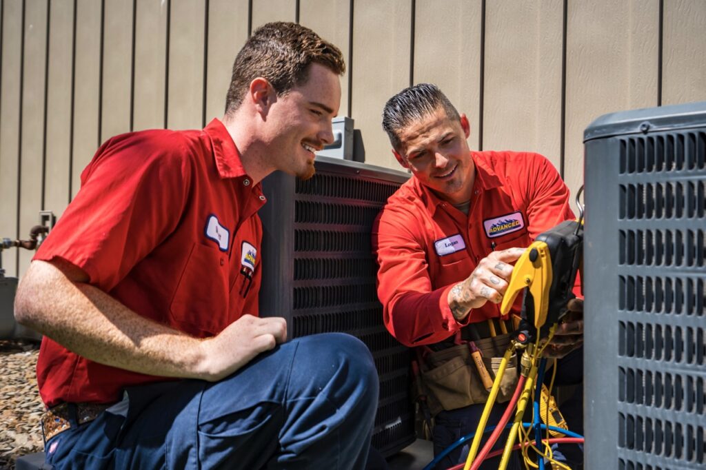 Two technicians finding the air conditioner's SEER rating.