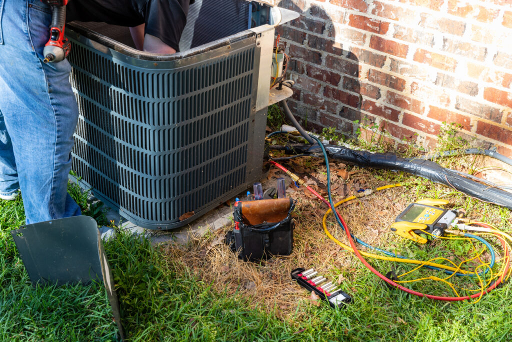 Technician working on an outdoor air conditioning unit