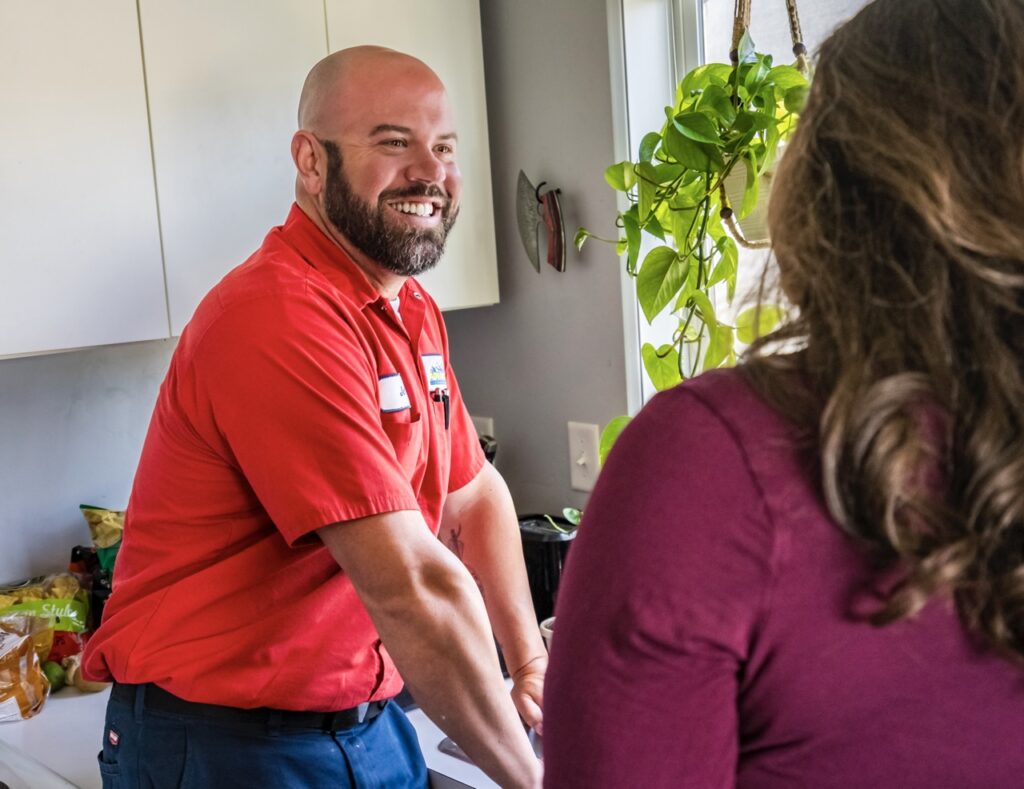 Plumbing service technician helping customer.