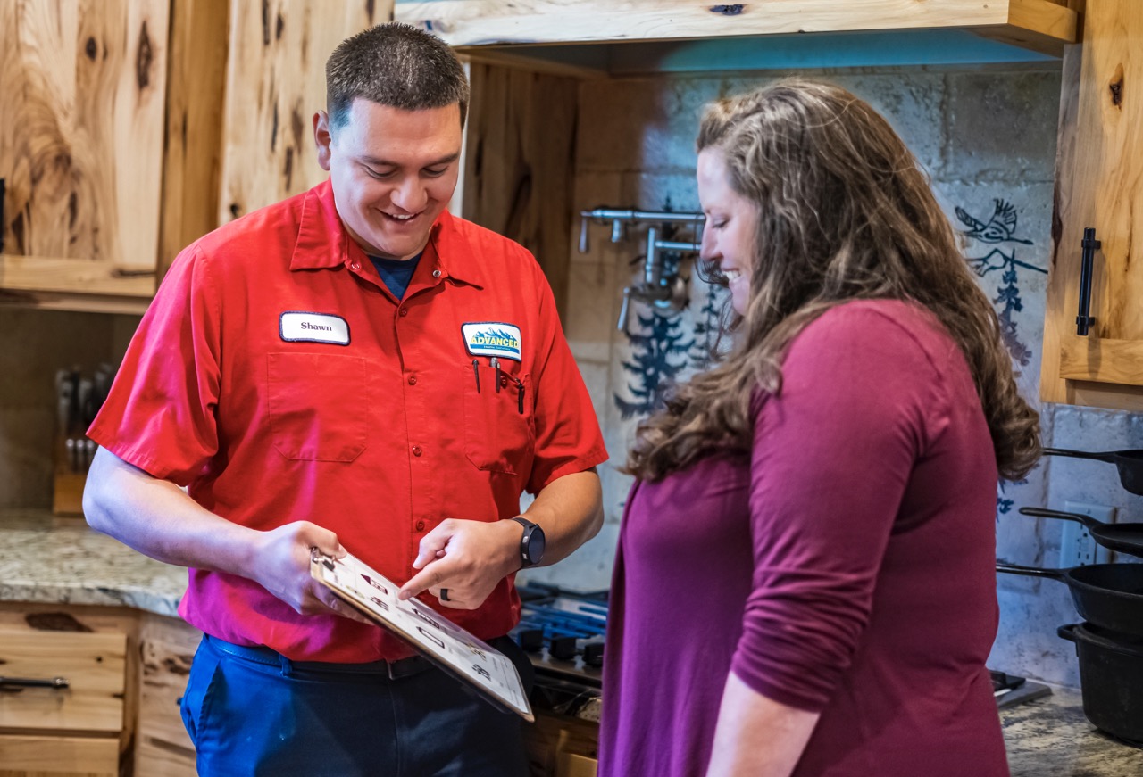 Technician recommending services to a customer after inspection.